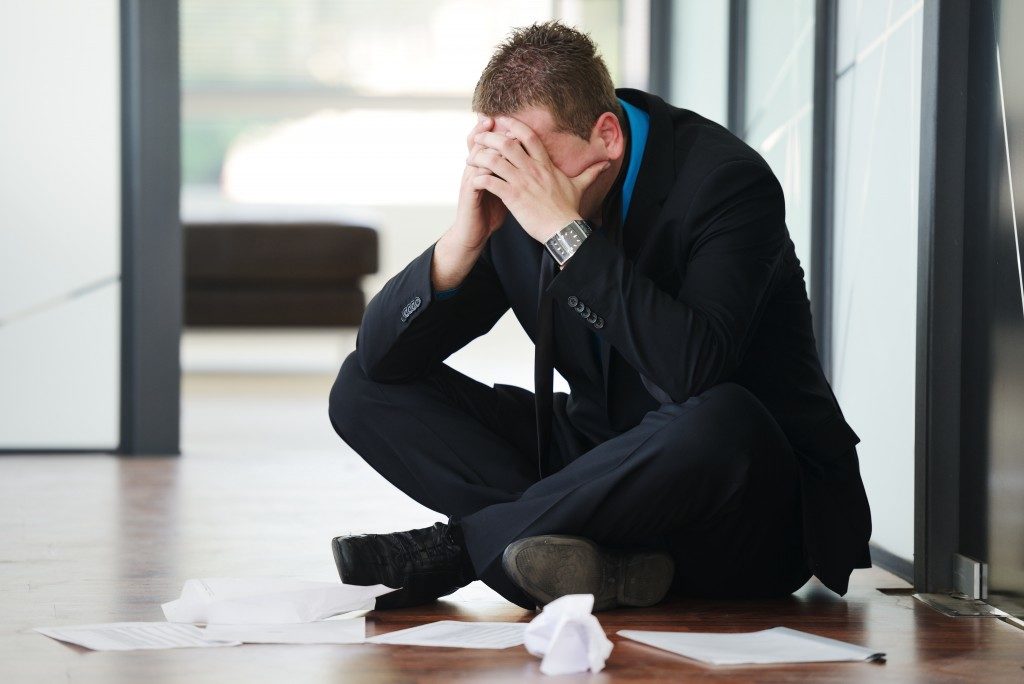 Stressed businessman sitting on the floor