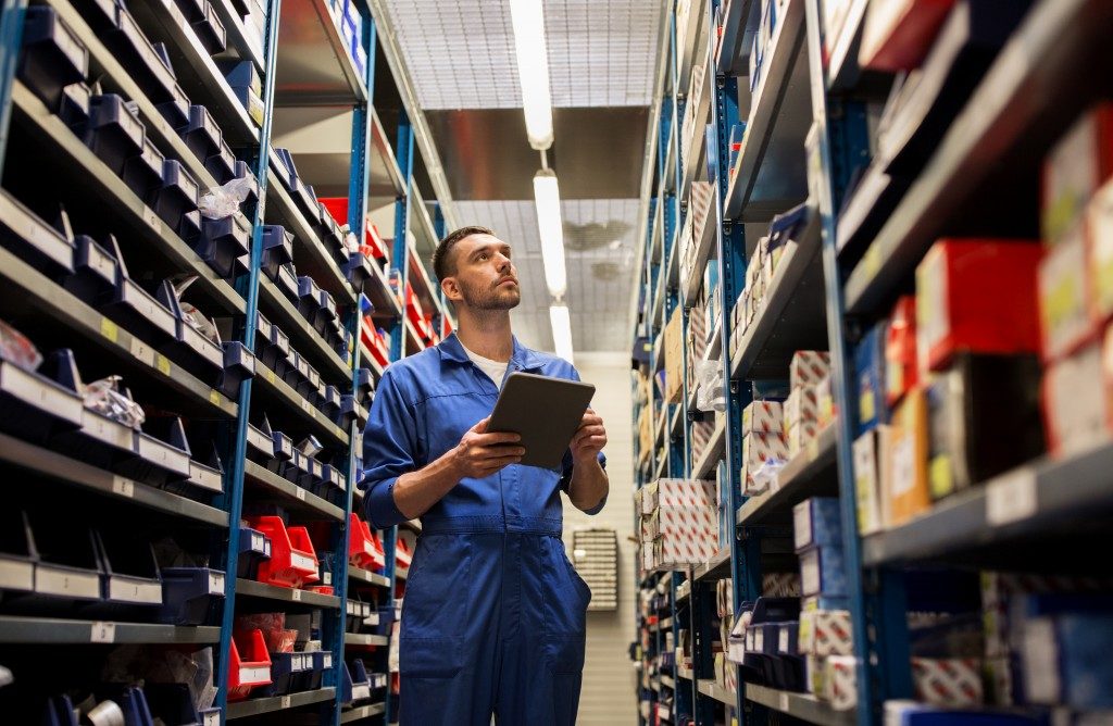 Male warehouse worker checking shelves