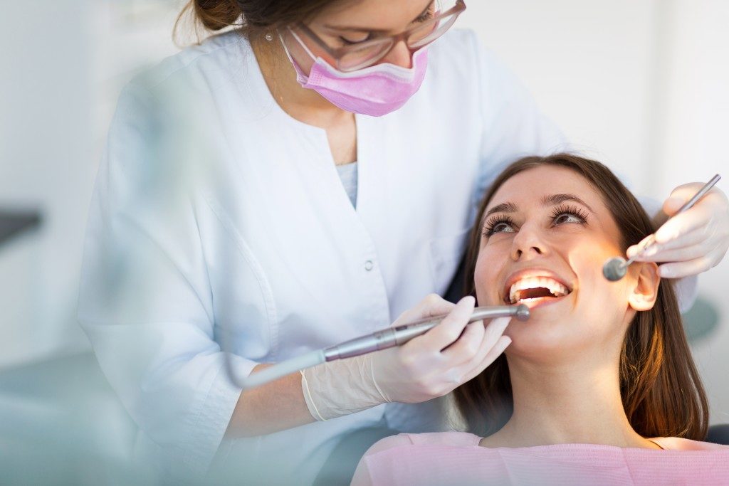 a woman having her teeth check by her dentist