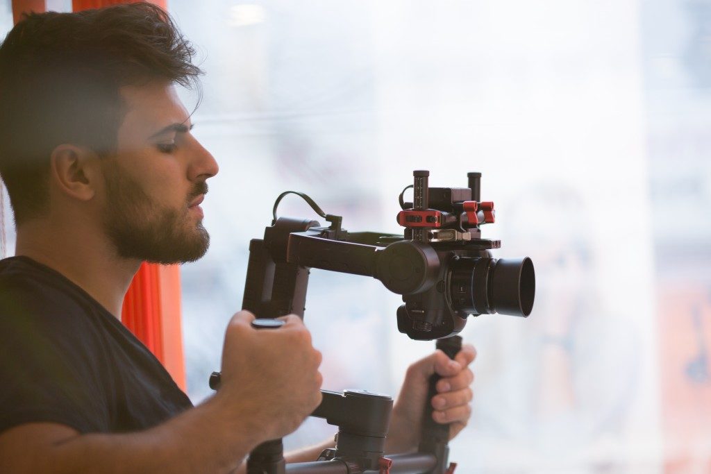 man filming with his camera