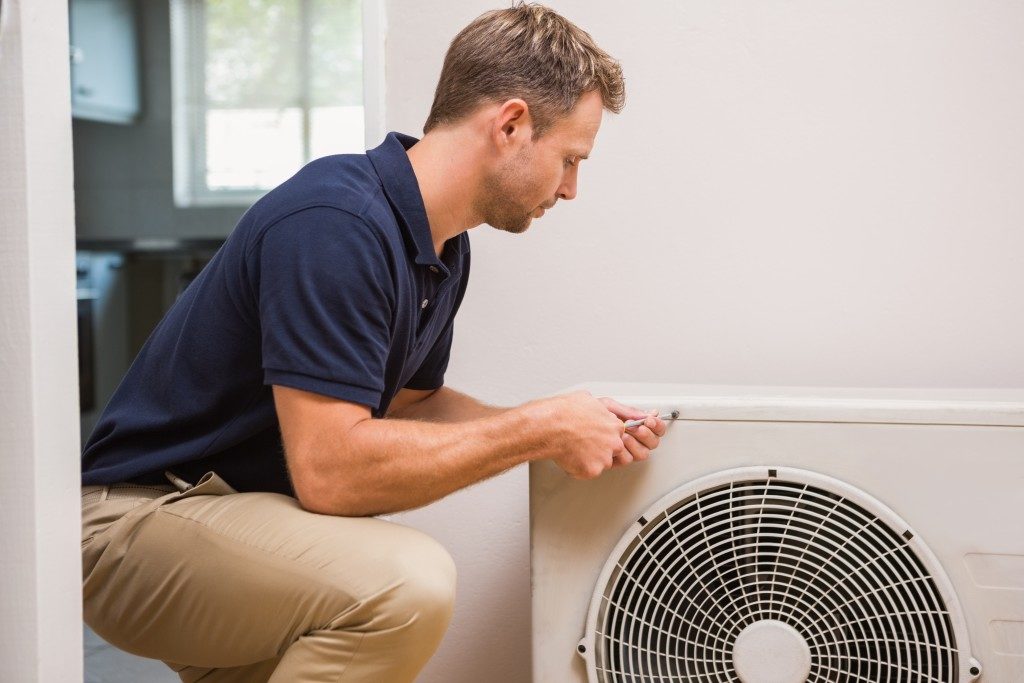 man repairing air conditioning system