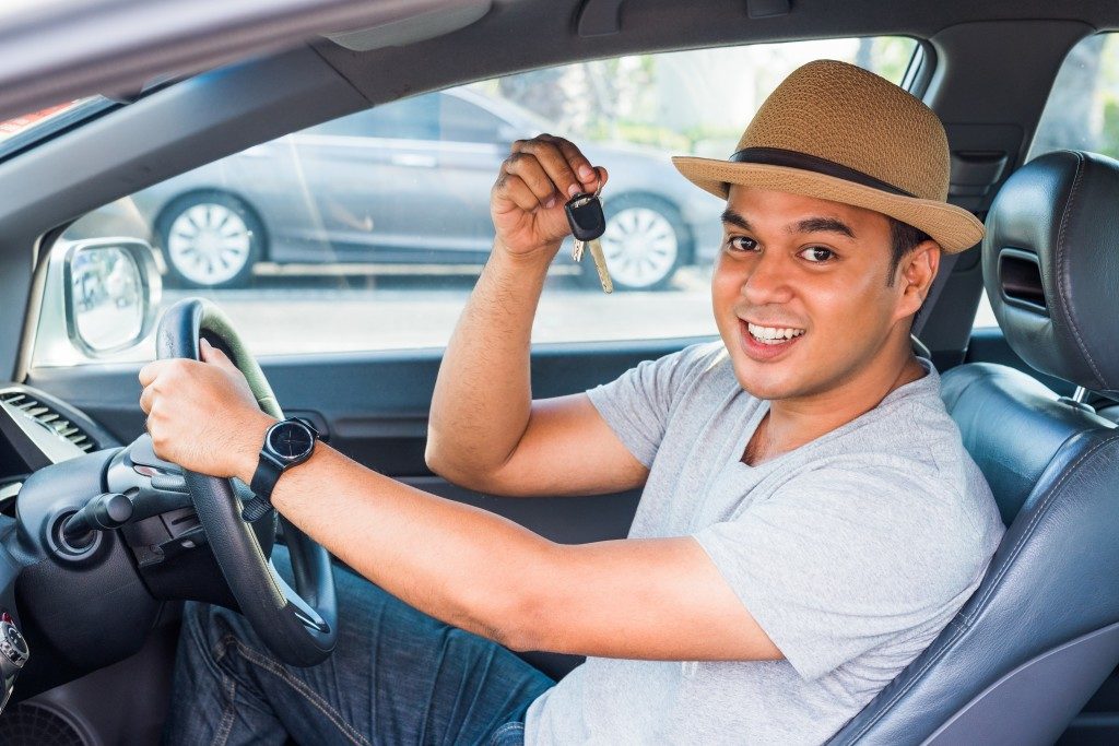 Man inside his car while holding up his car keys