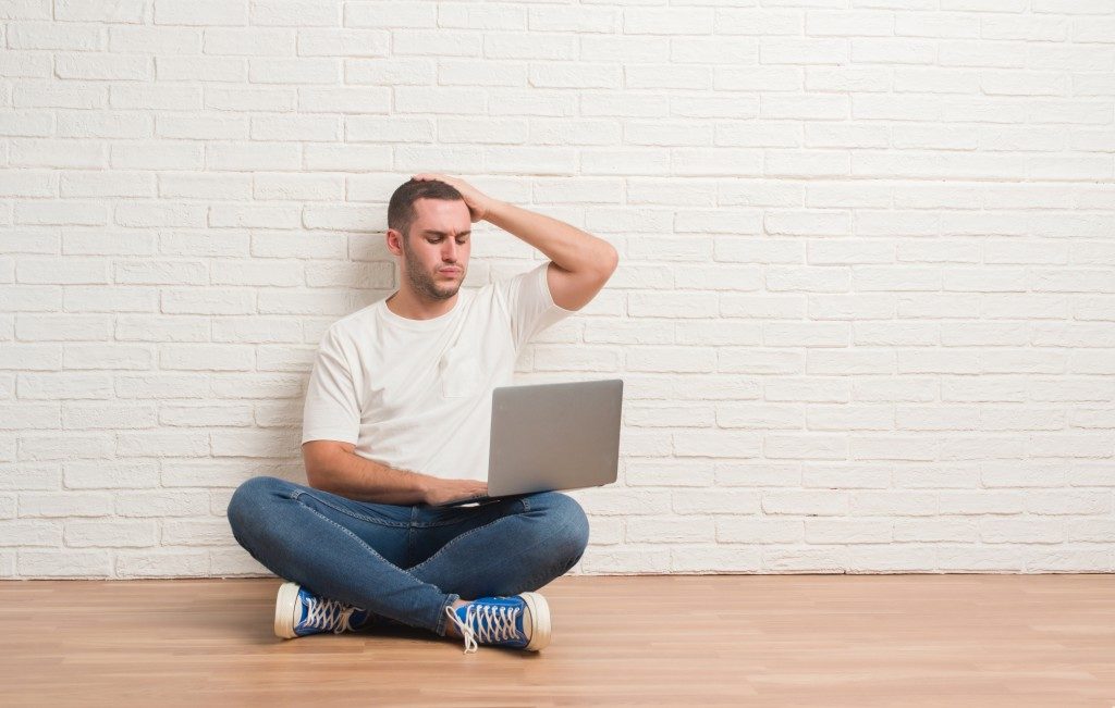 man using his laptop and feeling troubled