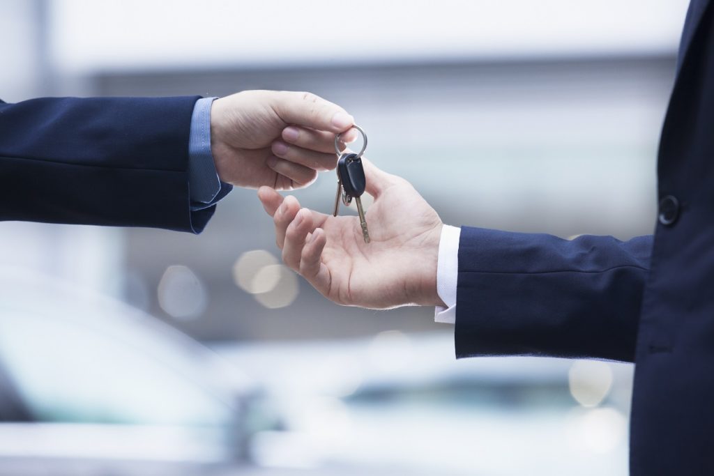 person handing car key