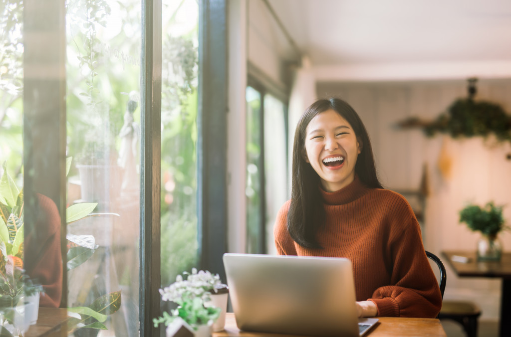 woman laughing while working