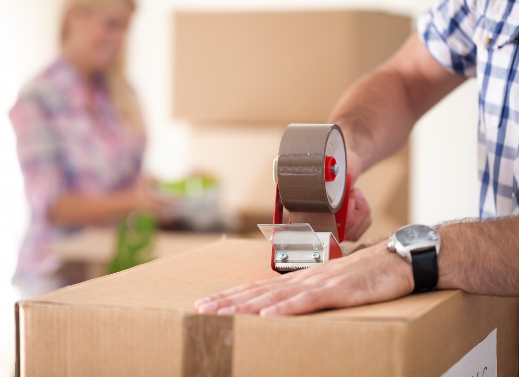 man sealing a box