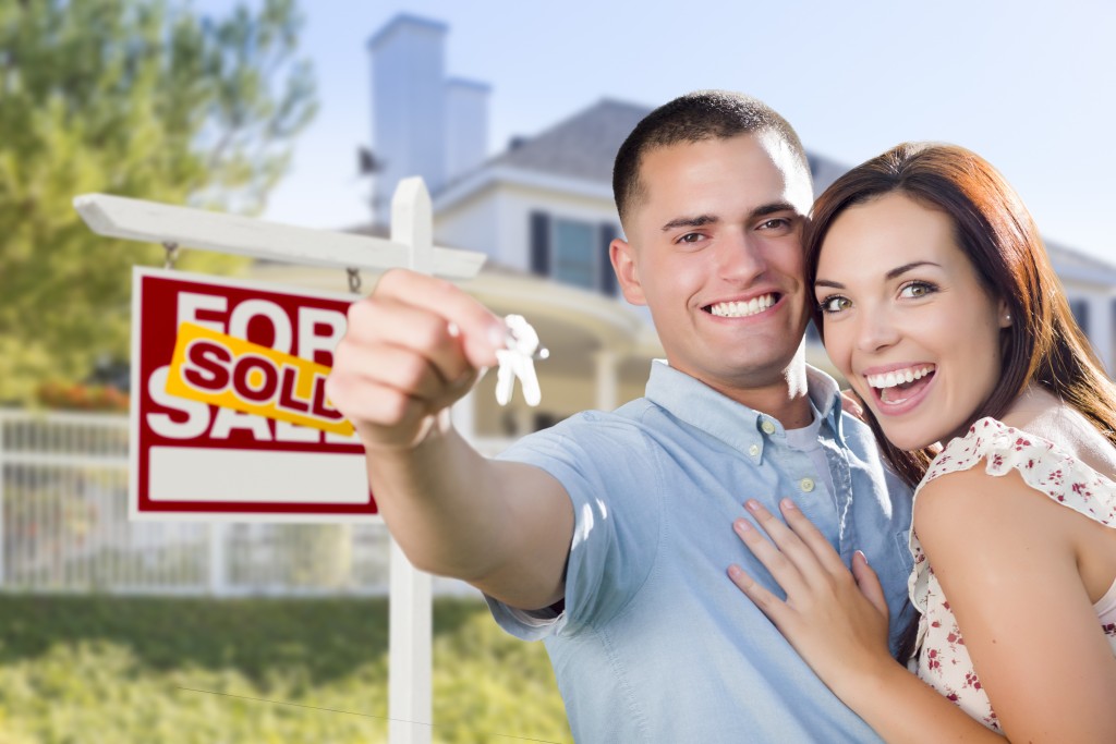 couple holding keys to their new house