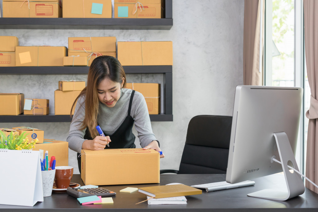 woman writing on box