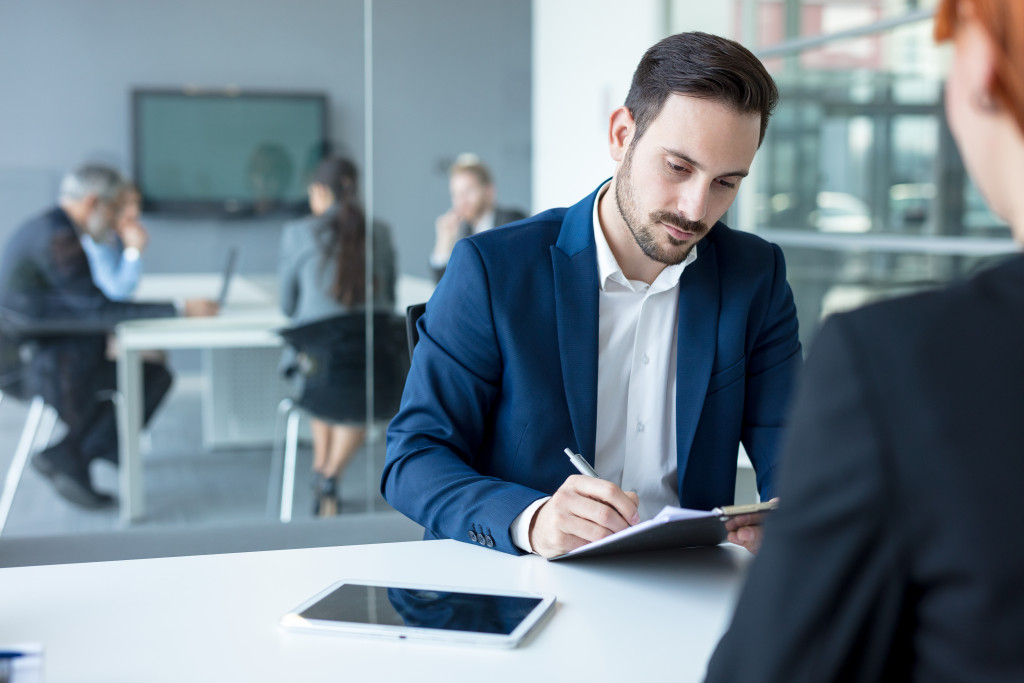 businessman writing at his notebook while in a meeting