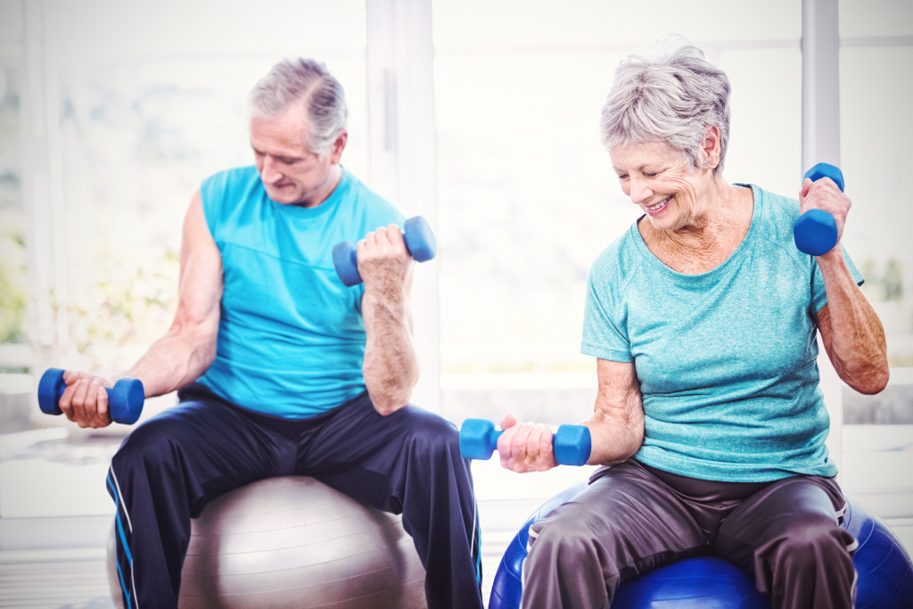 Old couple working out with dumbbell together 