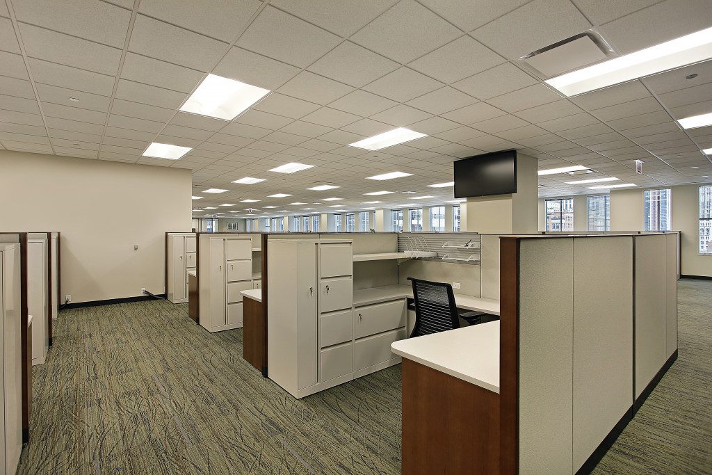 an empty office with many workspace and cubicles available
