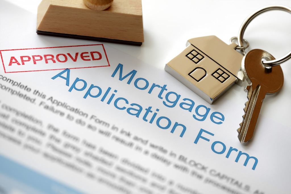 An approved mortgage application and a house key and a rubber stamp