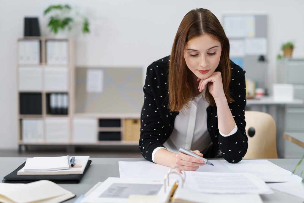 a woman in an office checking documents and contracts 
