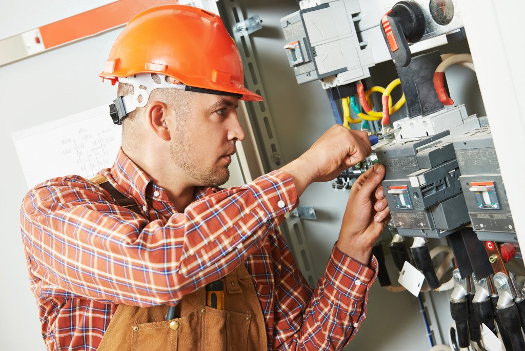 An electrical engineer working on industrial grade wirings and fuse boxes.