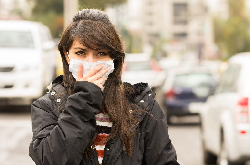 Woman struggling to breathe with mask due to air pollution