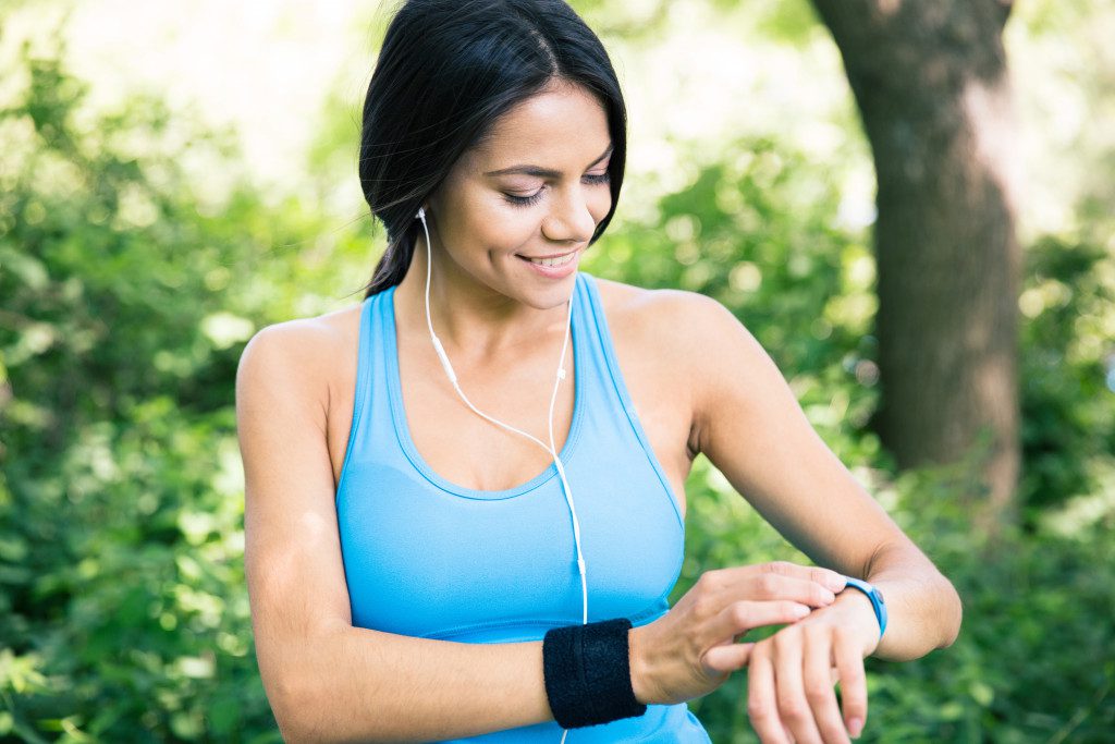 On her wrist, a female employee in sportswear is checking her fitness tracker.