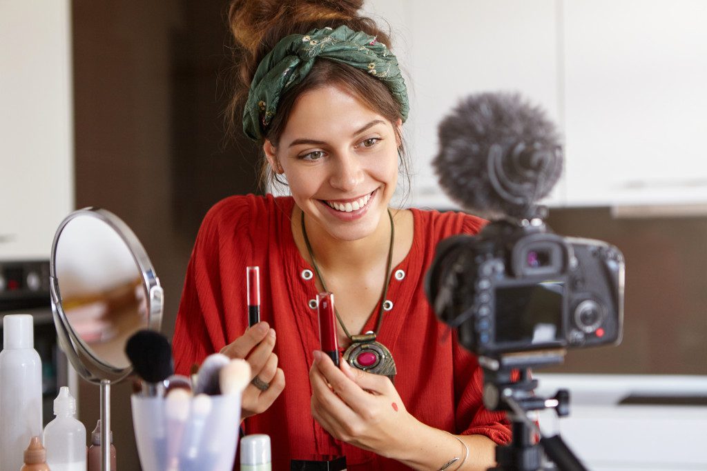 woman doing make up in front of a camera