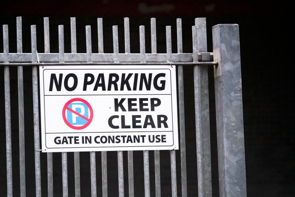 No parking sign board on a black color gate 