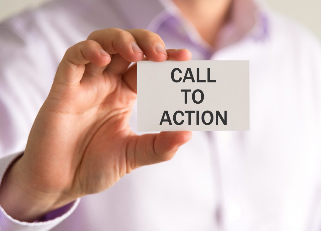 A person holding a card with Call to Action written on it