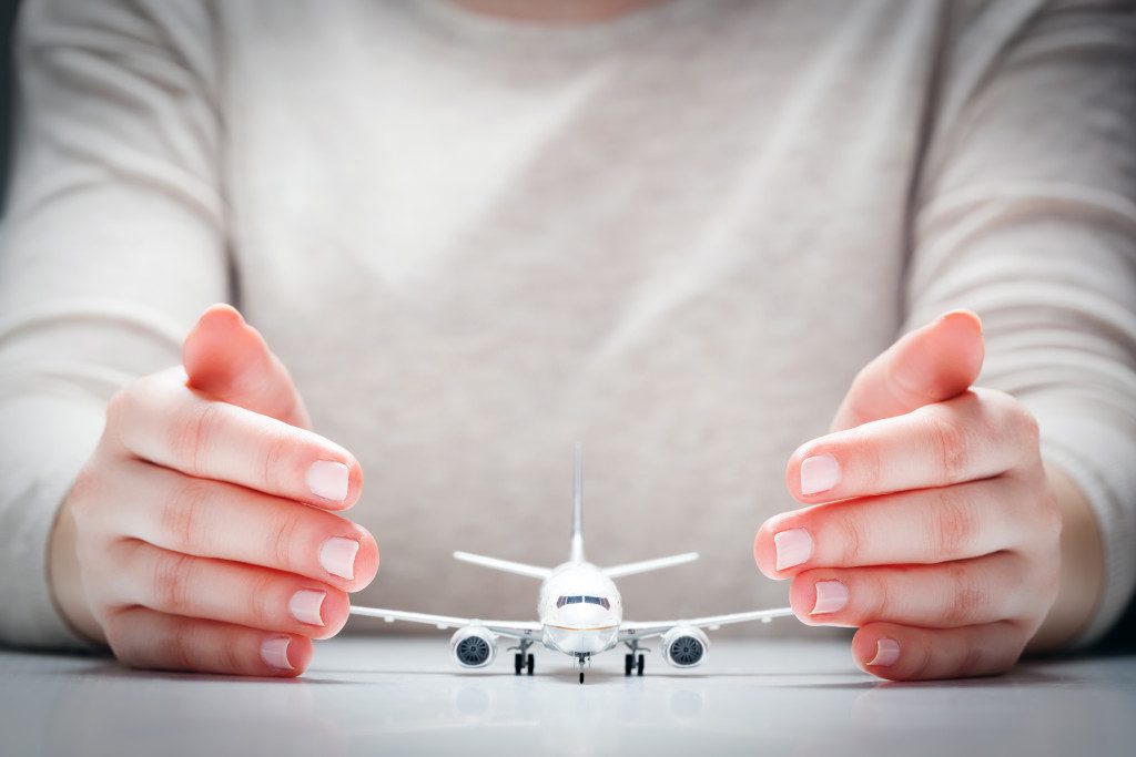 airplane model surrounded by hands