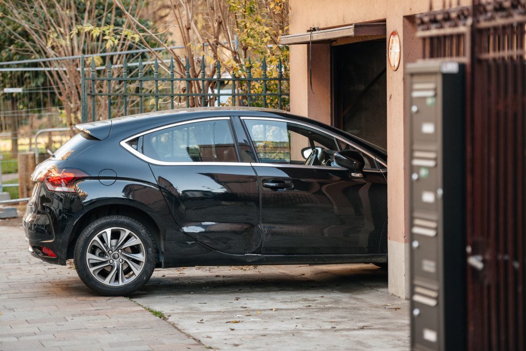 a black car entering a house's garage